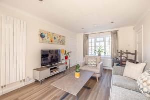 a living room with a couch and a tv at Stylish 1 Bedroom Retreat in Maidenhead in Maidenhead