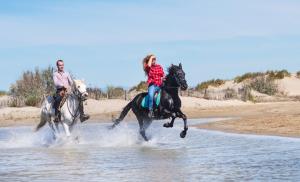 two people riding horses in the water on the beach at Casa com piscina para 10 pessoas - 5 min da praia Esposende in Esposende