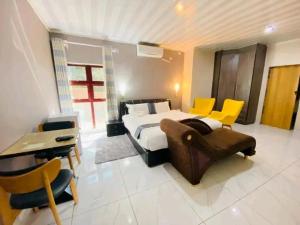 a bedroom with a bed and a desk and chairs at Kanyi GuestHouse in Palatswe