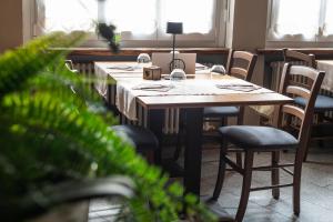 a dining room with tables and chairs and windows at Locanda Poncini in Maggia