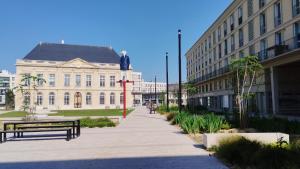 a statue of a man on a pole in front of a building at LA TERRASSE DE NOTRE DAME in Le Havre