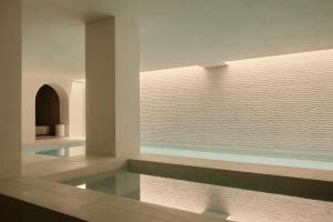 a swimming pool in a room with a window at Rosewood Amsterdam in Amsterdam