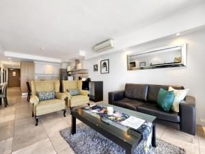 a living room with a couch and a table at Birds-eye canal view - Walk to CTICC and V&A Waterfront! in Cape Town