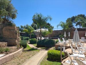 a group of chairs and umbrellas in a garden at Residence Casale Verderame in Trapani