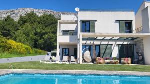eine Villa mit Swimmingpool und ein Haus in der Unterkunft Holiday house in Split with sea view, terrace, air conditioning, WiFi 4937-1 in Solin