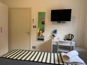 a bedroom with a bed and a desk with a television at United Residence in Mestre