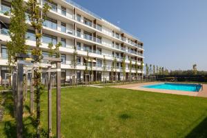 un immeuble d'appartements avec une pelouse et une piscine dans l'établissement Seaside Apartamenty Ku Morzu Sianożęty 150m to the beach, swimming pool, à Sianożęty