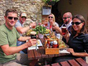 a group of people sitting around a table with drinks at The Bugle Coaching Inn in Yarmouth +2 photos
