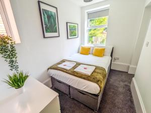 - une petite chambre avec un lit et des oreillers jaunes dans l'établissement RUBY Delightful Suite Moseley Mews, Birmingham By STAE-Homes, à Birmingham