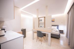 a small apartment with a desk and a bed at Blue Wave Suites - Ixia in Ialysos
