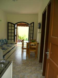a room with a kitchen and a table and a bed at Chale Colonial in Ubatuba