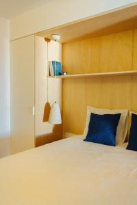 a bedroom with a large bed with blue pillows at Hidalga Piso con terraza y vistas al mar in Puertito de Güímar