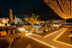 an outdoor patio with furniture and lights at night at Mykonos Eight in Mýkonos City +75 photos