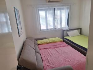 a small bedroom with a bed and a window at Easy 2 bedroom apartment, Makenzi beach in Aglantzia