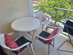 a white table and chairs on a balcony at Easy 2 bedroom apartment, Makenzi beach in Aglantzia