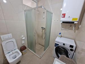 a bathroom with a shower and a washing machine at AURORA Apartment Shëngjin Kune in Shëngjin +7 photos