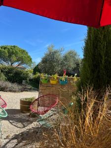 a red umbrella and some plants in a garden at La Grange de la Maison des chats - Gîte en Quercy in Saint-Amans-du-Pech