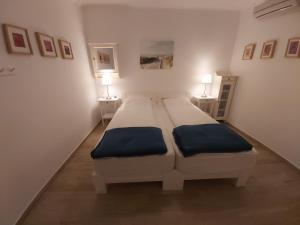 a white bedroom with two beds and two lamps at Our dream, seaview, near the beach in Stelida