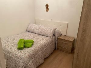 a bedroom with a bed with a green pillow on it at Casa centro histórico de Viveiro in Viveiro