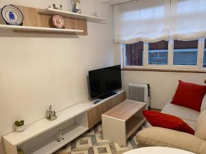 a living room with a television and a couch at Casa centro histórico de Viveiro in Viveiro