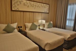 a hotel room with two beds and a window at فندق ديوان الهجرة in Medina