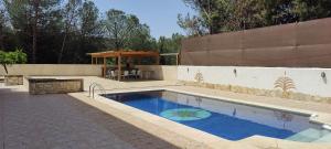 a swimming pool with a table and a pavilion at Lake View Villa in Iznájar