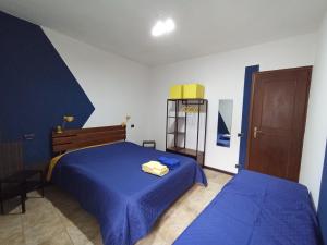 a bedroom with two beds with blue sheets at Ortacolorhome BlueHome-Boleto in Madonna del Sasso