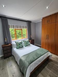 a bedroom with a large bed and a window at Roux Casa in Swellendam
