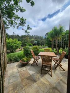 a patio with a wooden table and chairs at Roux Casa in Swellendam