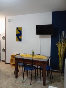 a dining room table with chairs and a tv at Ortacolorhome BlueHome-Boleto in Madonna del Sasso