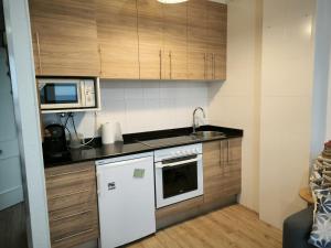 a small kitchen with a sink and a microwave at Ensenada Dichosa in Suances