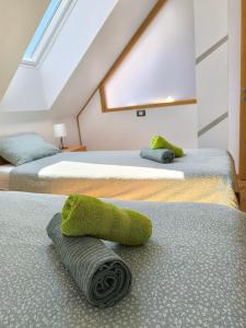 two beds with green towels on them in a room at Apartma Tima in Bovec