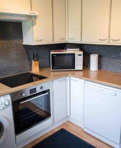a kitchen with a microwave oven and a stove at Ardmore Holiday Cottage in Trumpan