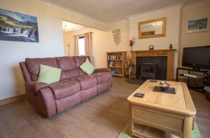 a living room with a couch and a fireplace at Ardmore Holiday Cottage in Trumpan