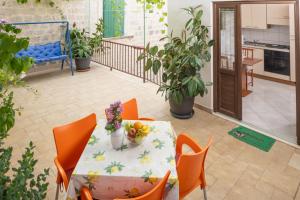 a table and chairs on a balcony with fruit on it at Apartments Damjanic Jerko in Vrboska