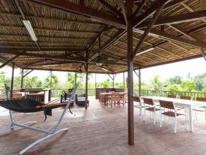 een paviljoen met een hangmat en tafels en stoelen bij Garden Palace Downtown Koror in Koror