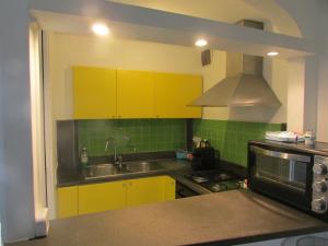 a kitchen with yellow cabinets and a sink at Piazzetta Sweet Home in Capri