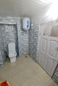 a small bathroom with a toilet and a door at The Heritage jasmine lodge B&B in Shimla +53 photos