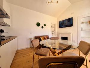 a living room with a glass table and chairs at Romantica Corte dei limoni Piscinas in Piscinas