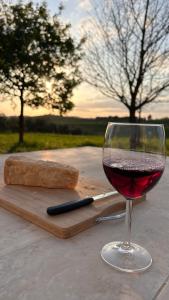 a glass of wine and a piece of bread on a table at Maremma Design in Manciano