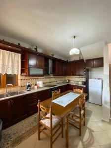 a kitchen with wooden cabinets and a wooden table at FarmHouse Qeparo in Qeparo
