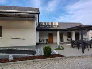 una casa con patio arredato con tavolo e sedie di Csengő Vendégház a Kiskőrös