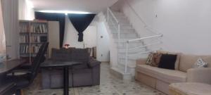 a living room with a couch and a staircase at Hostel & Pousada SANTOS PRAIA in Santos