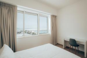 アブダビにあるSustainable Mayan Escape 2BR with Beach Accessのベッドと机と窓のある寝室 +35枚の写真