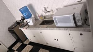 a kitchen counter with a microwave and a sink at Hostel & Pousada SANTOS PRAIA in Santos