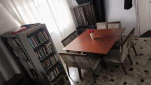 a dining room table and chairs with a book shelf at Hostel & Pousada SANTOS PRAIA in Santos