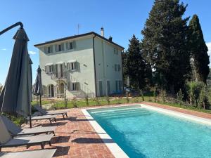 a house with a swimming pool in front of a building at Cascina del Riccio-Agriturismo Casa Raffaele in Ghizzano