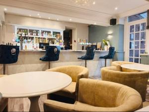 a restaurant with tables and chairs and a bar at Thomas Arms Hotel in Llanelli