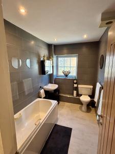 a bathroom with a tub and a sink and a toilet at The Wheel House - Private Front door and Free Parking in Edinburgh +11 photos