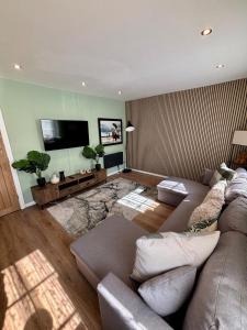 a living room with a couch and a flat screen tv at The Wheel House - Private Front door and Free Parking in Edinburgh